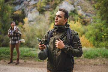 Adult man hiker look for path and directions on mobile phone