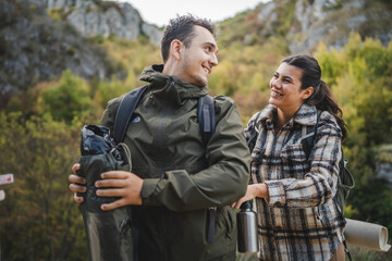Fototapeta premium Girlfriend help boyfriend to pack and fasten his backpack