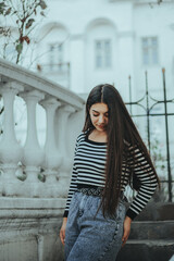 Stylish woman by metal fence in the city