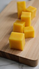 Wooden plank displaying stacked yellow cheese cubes