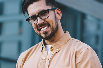 Half length portrait of happy man 30 years old looking at camera during break from using digital technology, cheerful Caucasian male blogger enjoying good internet connection on modern cellphone