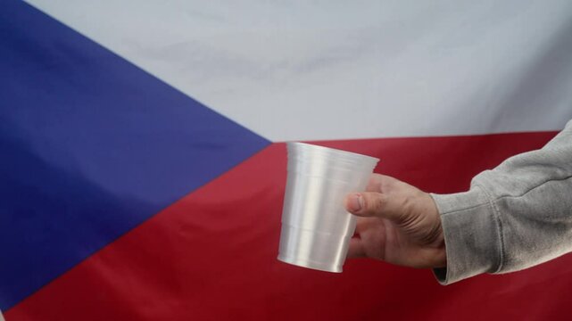 Rich woman throws czech koruna coin into plastic cup of homeless man who is asking for alms on Czechia flag background. Sharing and help each other. Poor life, unemployment, people below poverty line