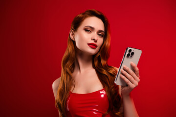 Photo of lovely attractive lady hold telephone eshop dressed sexy leather garment isolated on red...