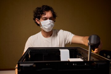 A man cleans a computer case with a vacuum in a bright room, stressing workspace tidiness