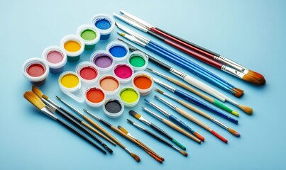 Naklejka premium A painting set with a variety of colors and brushes on a blue background