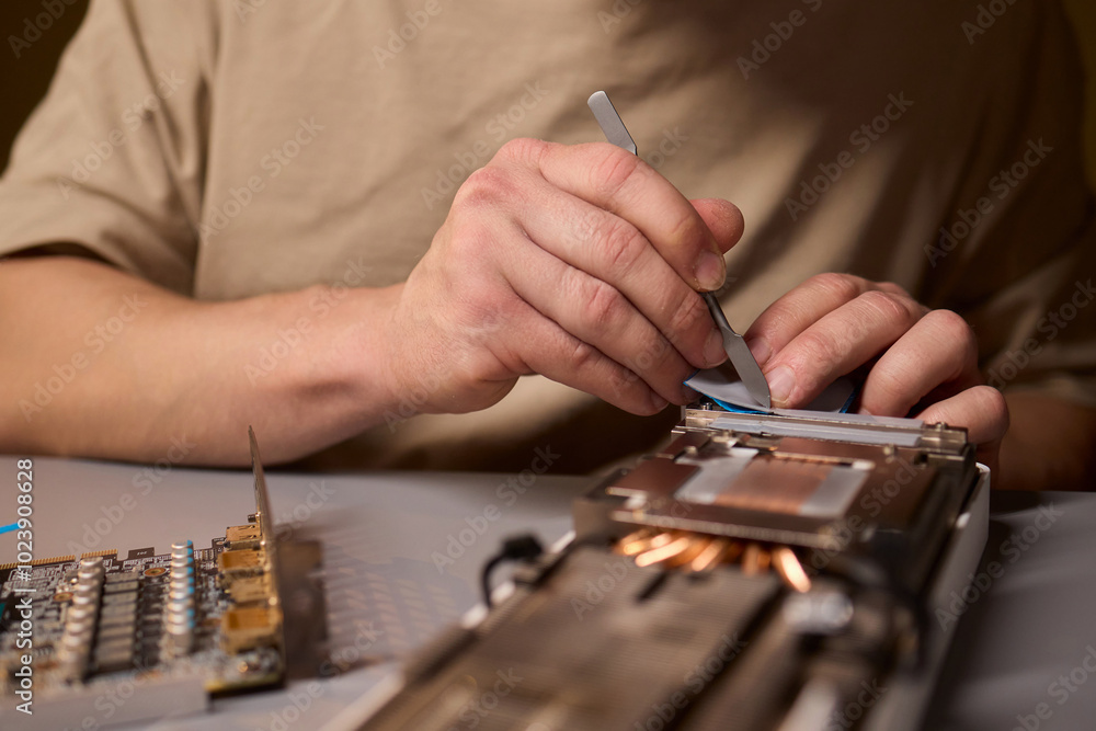 Aufkleber hand repairing a graphics card through the application of thermal paste for better performance