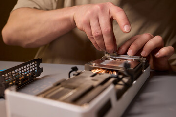 Fototapeta premium Hand Repairing a Graphics Card through the Application of Thermal Paste for Better Performance