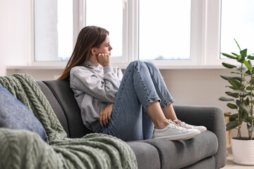 Obraz premium Loneliness concept. Sad teenage girl on sofa at home