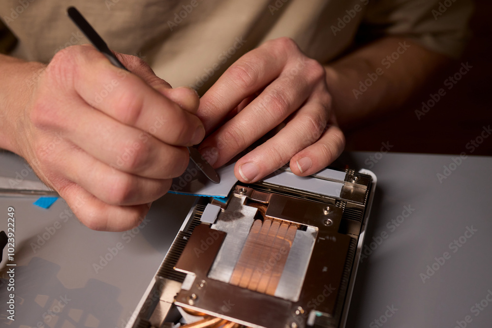 Aufkleber hand repairing a graphics card through the application of thermal paste for better performance