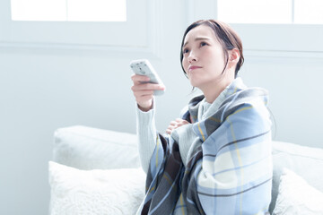 エアコンの温度を調整する女性