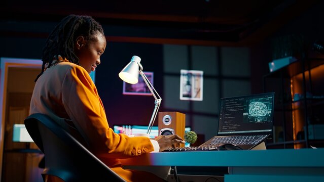 African american system engineer using AI system to write computer program code, html terminal window. Woman works with deep learning algorithms, artificial intelligence neural networks. Camera B.