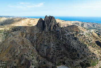 Mountains and Olive groves around Ghost Town from a drone, Pentedattilo Village, Calabria, Italy, Europe