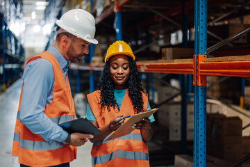 Warehouse workers checking inventory using clipboards