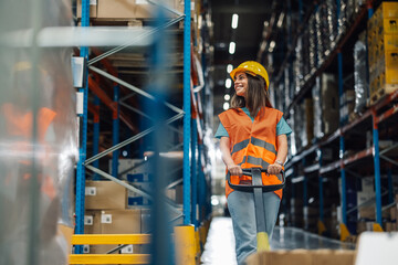 Female warehouse worker pulling pallet jack through a distribution center