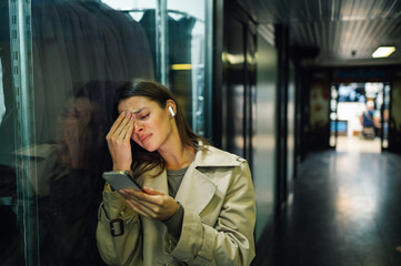 Stressed businesswoman reading bad news on smartphone and crying