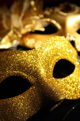 Beautiful golden carnival masks on black background, closeup