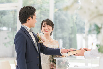 結婚式で聖書に手を重ねて宣誓・誓う新郎新婦
