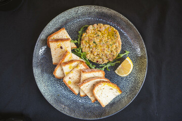 Tuna tartare paired with toast and a lime wedge, capturing the balance between rich, fresh tuna and crisp bread. A perfect dish for seafood lovers.