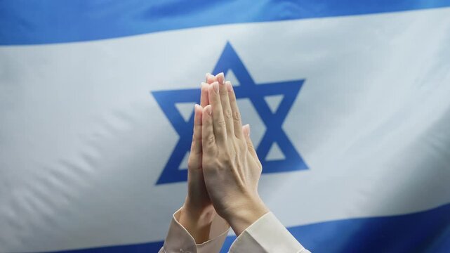 Jewish woman praying on star of David Israeli National flag. Hopeful prayer.