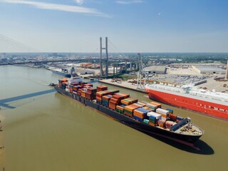 Container ship on the Savannah River passing under the Talmadge Memorial Bridge, Savannah, Georgia,...