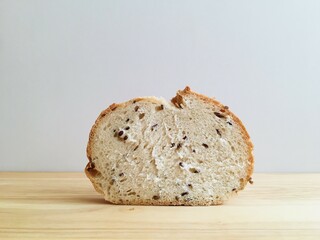 Slice of wheat bread with flax seeds on cutting board close-up