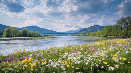 A serene river landscape adorned with colorful wildflowers and mountains in the background.