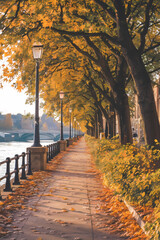 Naklejka premium Scenic autumn pathway lined with trees and lampposts, featuring vibrant yellow leaves along a tranquil riverbank.