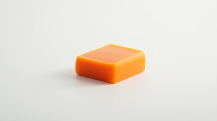 Fototapeta premium A simple orange soap bar on a light background, emphasizing its clean design and color.