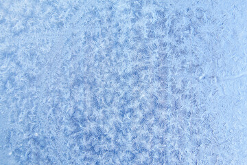 Frost patterns on frozen glass on a winter day. Winter frosty texture natural background