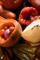 Close-up of roasted butternut squash, onions, tomatoes, and peppers with caramelized textures.