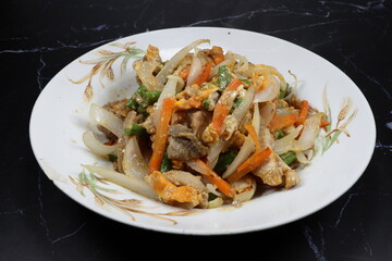 Fried and stirred sliced chicken with shredded carrot, onion and green bean serving on the plate. Famous clean and healthy menu in Asian restaurant. 