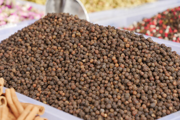 A large and fragrant heap of black peppercorns can be found in the bustling local market