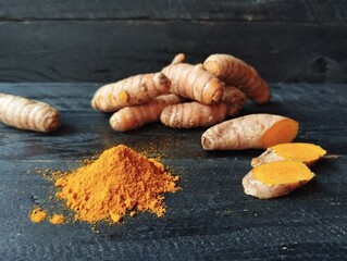 Turmeric powder and fresh turmeric on wooden table 