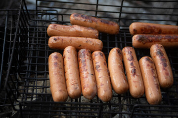 Sausages on a picnic. Roasting meat on coals. Cooking food on fire.