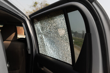 Obraz premium Cracked side car window glass on road . Damaged car window. .Car accident claims via insurance apps.
