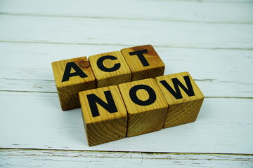 Act Now with wooden blocks alphabet letters top view on wooden background