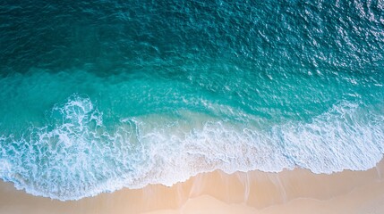 Fototapeta premium top-down seascape, azure blue waters meeting sandy shore, gentle wave patterns, sunlit ocean surface, tranquil coastal view, tropical beach landscape, high-resolution aerial shot
