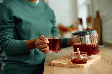 Close up of black woman making tea at home.