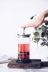 Red hibiskus hot tea in French press © Nelli Kovalchuk