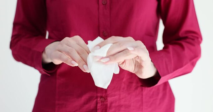 A woman in red shirt cleans her hands with a napkin
