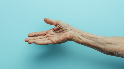 Close-up of an elderly man's hand resting against a light blue background, highlighting the unique textures and age-related signs of life