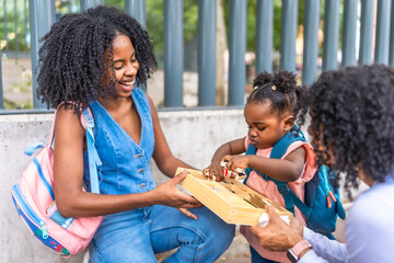 African family playing outside school building