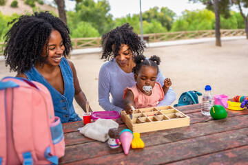 Fototapeta premium Granny, mother and girl playing with toys in the park