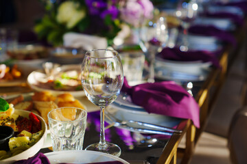 Beautiful festive table setting with flowers and purple napkins. 