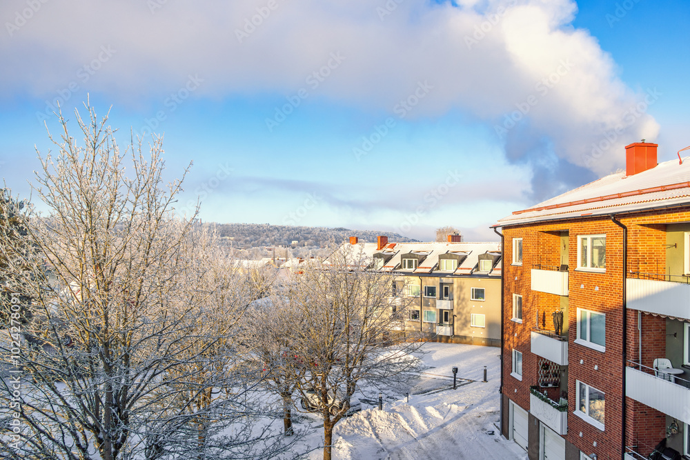 Sticker Apartment building with balconies a cold winter day with snow and frosty trees