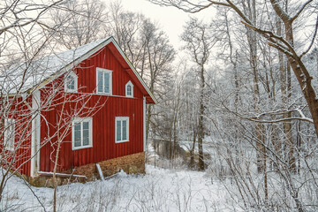 Red wooden cottage by a river a cold winter day © Lars Johansson