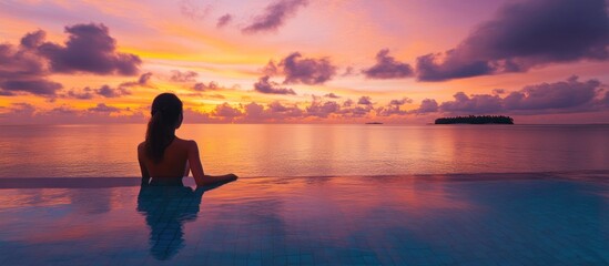 Fototapeta premium Silhouette of a Woman Enjoying Sunset Over the Ocean