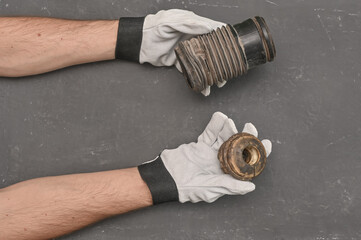 The shock absorber cover and the shock absorber bump are in the hands of a mechanic.