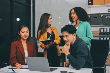 Young corporate employees sitting in office looking at laptop screen reading good news excited happy team diverse people celebrating victory win command success excellent result professional teamwork