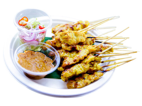 Delicious Chicken Satay: A mouthwatering platter of grilled chicken satay skewers, served with a vibrant side salad and rich peanut sauce. Perfect for food blogs, restaurant menus.